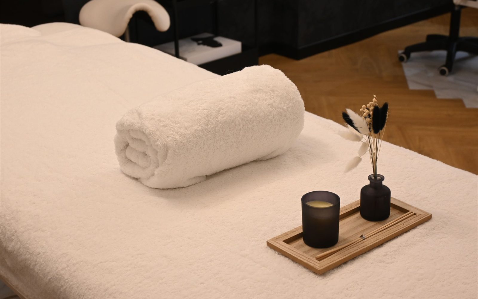 Calm treatment room with a massage table, folded towels and a candle