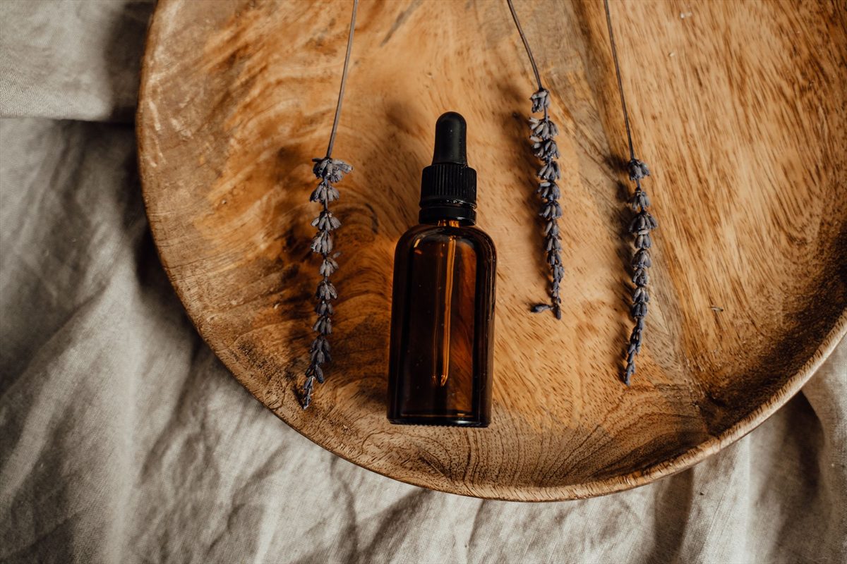Aromatherapy oil bottles and dropper on a pale surface